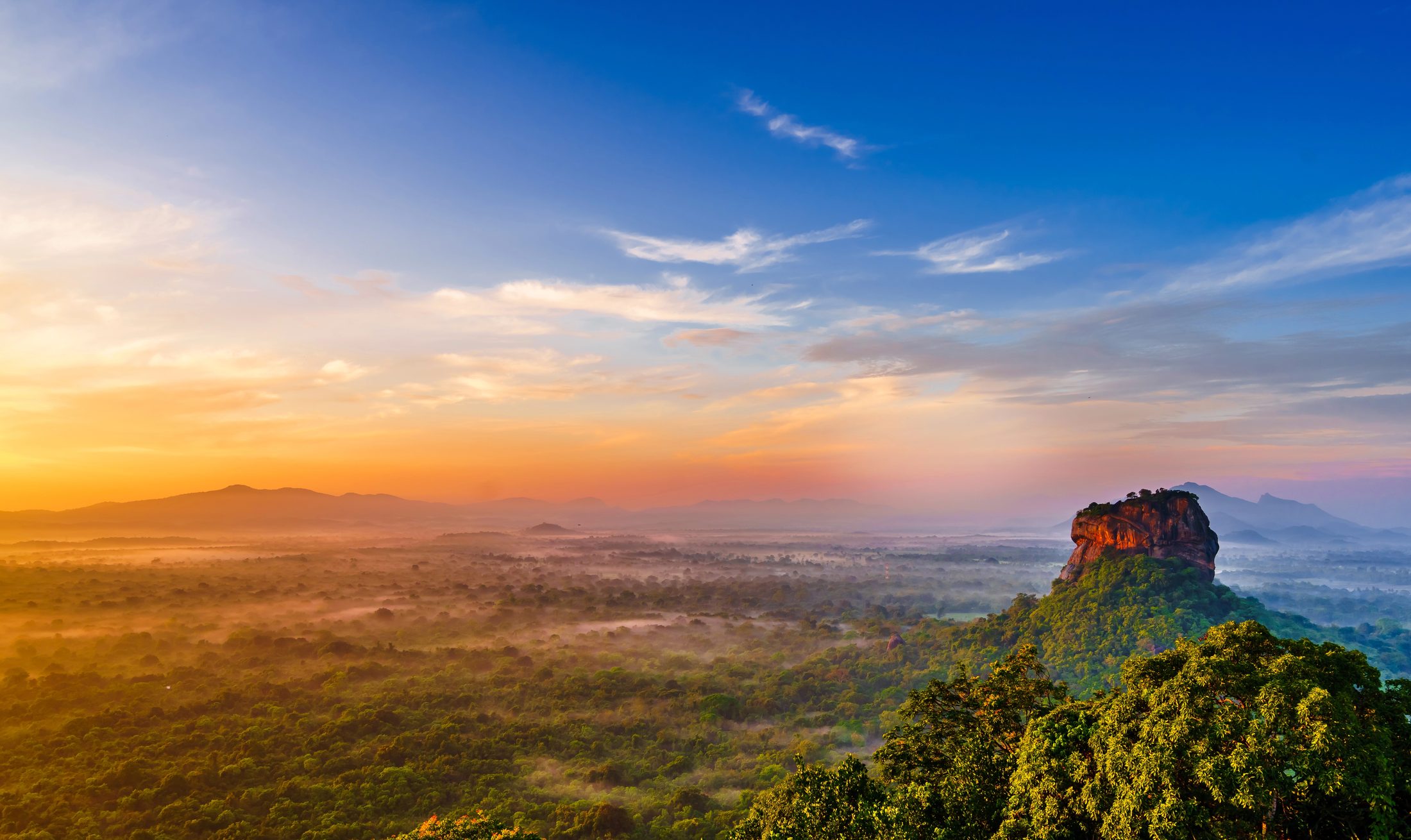 Sigiriya rock fortress rising above the jungle at sunset in Sri Lanka